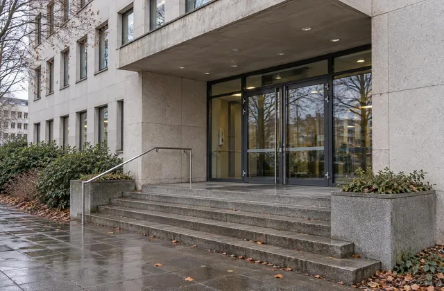 Eingang eines Verwaltungsgebäudes mit Treppe und Glastüren